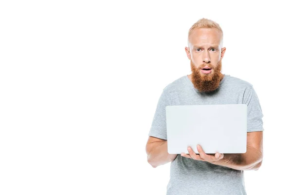 Homme barbu choqué en utilisant un ordinateur portable, isolé sur blanc — Photo de stock