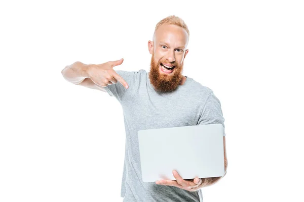 Збуджений бородатий чоловік вказує на ноутбук, ізольований на білому — стокове фото