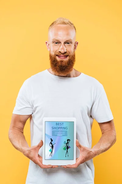 Homem barbudo mostrando tablet digital com melhores compras na tela, isolado no amarelo — Fotografia de Stock