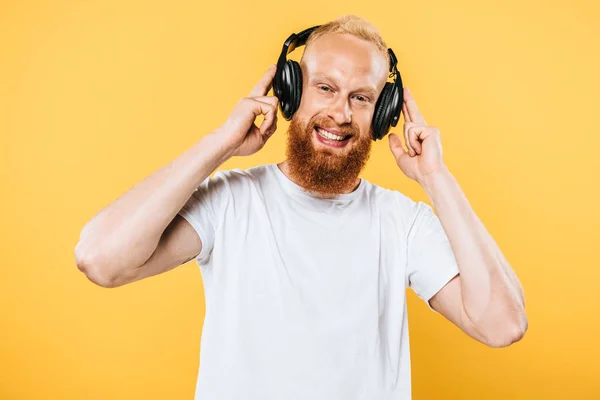 Homme barbe joyeux écoutant de la musique avec écouteurs, isolé sur jaune — Photo de stock