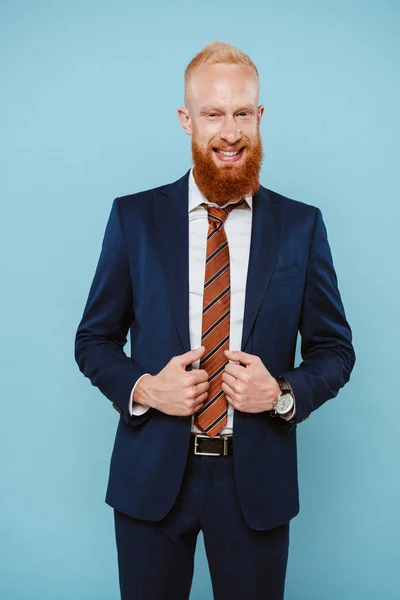 Счастливый бородатый бизнесмен в костюме, одинокий на голубом — стоковое фото