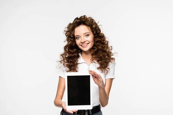 Привлекательная улыбающаяся женщина показывает цифровой планшет с чистым экраном, изолированный на белом — стоковое фото