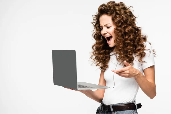 Сердита красива жінка, що кричить на ноутбуці, ізольована на білому — стокове фото