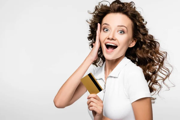 Belle fille surprise tenant carte de crédit, isolé sur blanc — Photo de stock