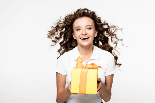 Attraktive lockige Mädchen mit gelben Geschenkbox, isoliert auf weiß — Stockfoto