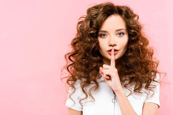 Hermosa chica rizada mostrando símbolo de silencio, aislado en rosa - foto de stock