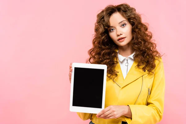 Belle fille bouclée montrant tablette numérique avec écran blanc, isolé sur rose — Photo de stock