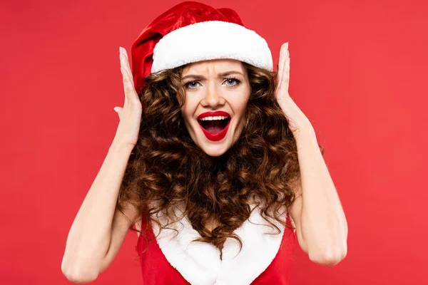 Bella ragazza sorpresa in posa in costume da Babbo Natale, isolato sul rosso — Foto stock