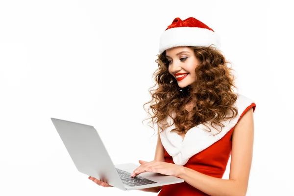 Attraente donna in costume da Babbo Natale e cappello utilizzando il computer portatile, isolato su bianco — Foto stock