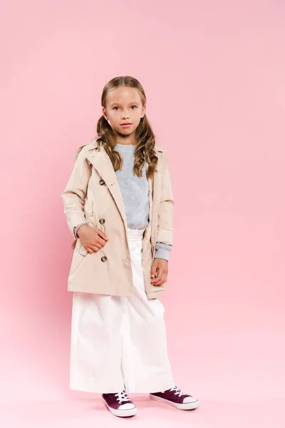 Niedliches Kind im Herbst-Outfit mit Hand in Tasche auf rosa Hintergrund — Stockfoto