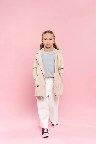 Kind im Herbst-Outfit blickt in Kamera auf rosa Hintergrund — Stockfoto