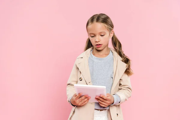 Nettes Kind hält mit digitalem Tablet isoliert auf rosa — Stockfoto