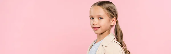 Panoramaaufnahme eines lächelnden Kindes, das isoliert auf rosa Kamera schaut — Stockfoto