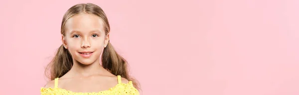 Panoramic shot of smiling kid looking at camera isolated on pink — Stock Photo