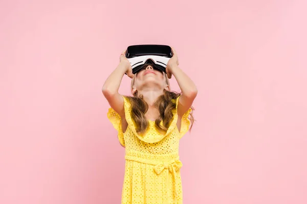 Kind mit Virtual-Reality-Headset schaut isoliert auf rosa — Stockfoto