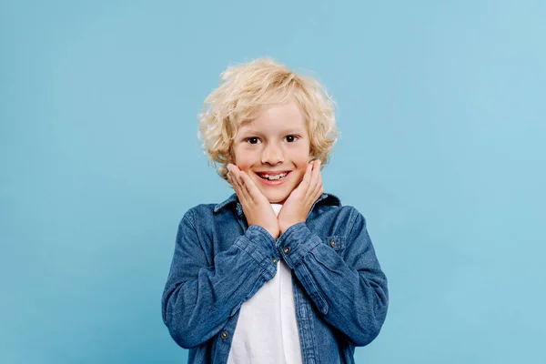 Enfant souriant et choqué regardant la caméra isolée sur bleu — Photo de stock