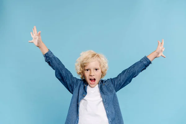 Glückliches und nettes Kind mit ausgestreckten Händen, die isoliert auf blau schreien — Stockfoto