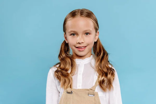 Smiling and cute kid looking at camera isolated on blue — Stock Photo