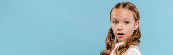 Panoramic shot of shocked and cute kid looking at camera isolated on blue — Stock Photo