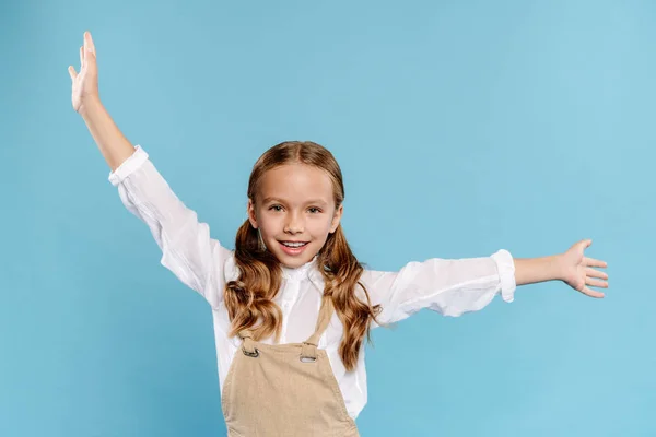 Smiling and cute kid with outstretched hands looking at camera isolated on blue — Stock Photo