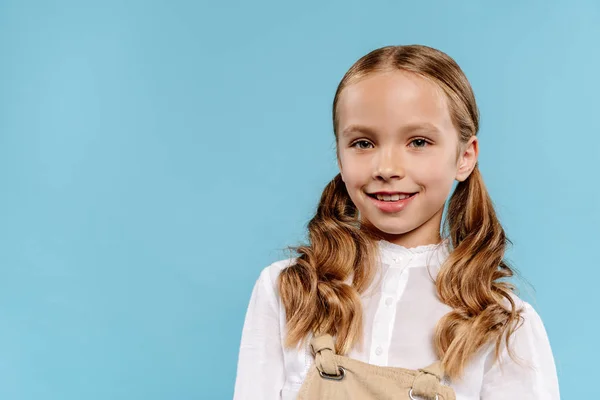 Smiling and cute kid looking at camera isolated on blue — Stock Photo