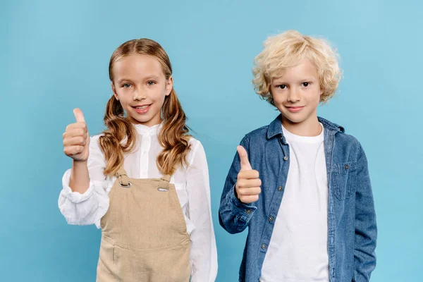 Lächelnde und niedliche Kinder, die in die Kamera schauen und Vorlieben zeigen, die isoliert auf blau sind — Stockfoto