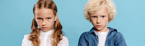 Panoramic shot of sad and cute kids looking at camera isolated on blue — Stock Photo