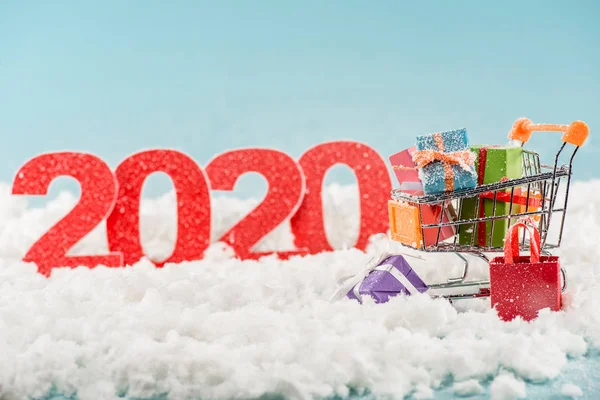 Selektiver Zahlenfokus 2020 und Weihnachtsgeschenke im Warenkorb — Stockfoto