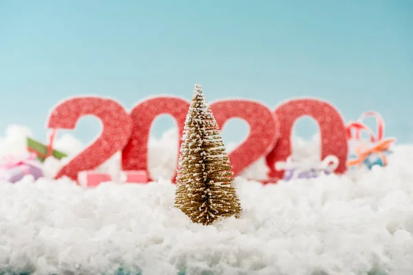 Enfoque selectivo del árbol de Navidad y los números 2020 en el fondo - foto de stock