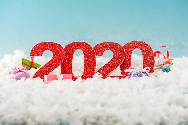 Zahlen 2020 und Weihnachtsgeschenkboxen im weißen Schnee — Stockfoto