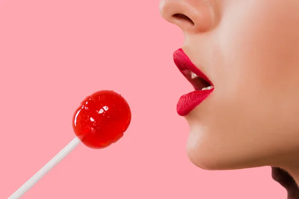 Cropped view of girl holding sweet lollipop isolated on pink — Stock Photo