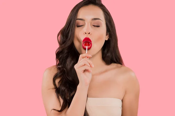 Attractive woman with closed eyes holding sweet lollipop isolated on pink — Stock Photo