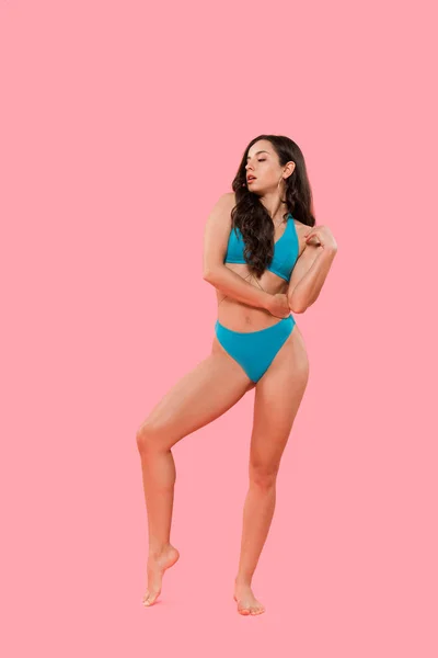 Femme sexy en maillot de bain bleu debout isolé sur rose — Photo de stock
