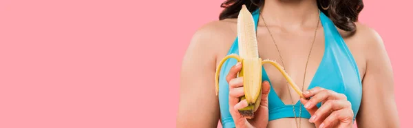 Panoramic shot of young woman peeling banana isolated on pink — Stock Photo