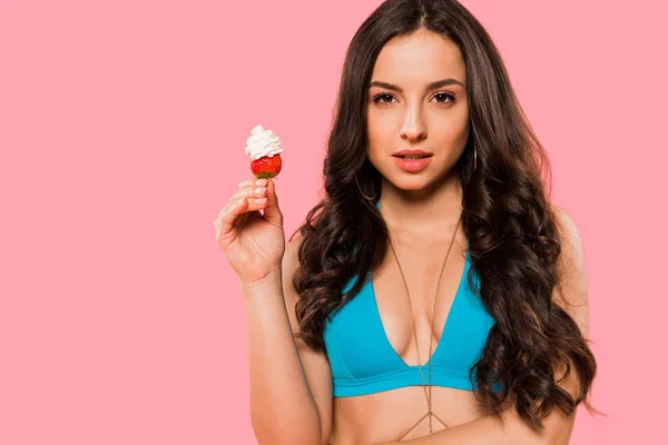 Sexy Frau hält Erdbeere mit Schlagsahne isoliert auf rosa — Stockfoto