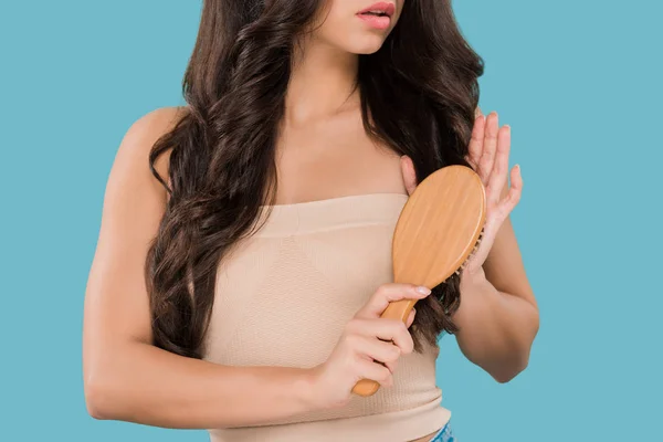 Corte vista de menina escovação brilhante cabelo isolado no azul — Fotografia de Stock