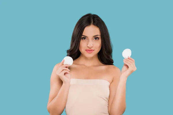 Attractive woman holding cotton pads isolated on blue — Stock Photo