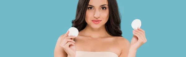 Panoramic shot of attractive woman holding cotton pads isolated on blue — Stock Photo