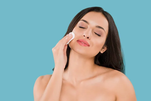 Happy woman holding cotton pad near clean face isolated on blue — Stock Photo