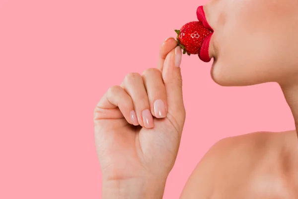 Vue recadrée de femme sexy avec lèvres rouges manger fraise isolé sur rose — Photo de stock