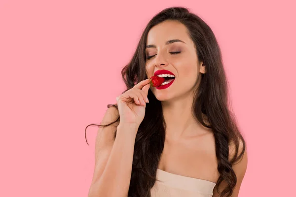Happy woman with red lips eating strawberry isolated on pink — Stock Photo