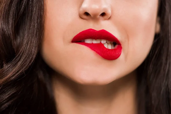 Cropped view of young woman biting red lips — Stock Photo