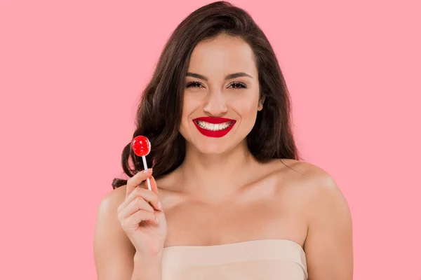 Happy woman with red lips holding lollipop isolated on pink — Stock Photo