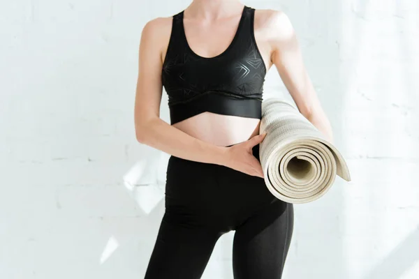 Recortado vista de mujer en ropa deportiva celebración yoga mat - foto de stock