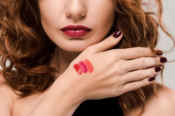 Cropped view of woman with lipstick palette on hand isolated on grey — Stock Photo