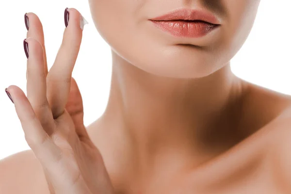 Обрезанный вид обнаженной женщины с кремом для лица на пальце изолированы на белом — стоковое фото