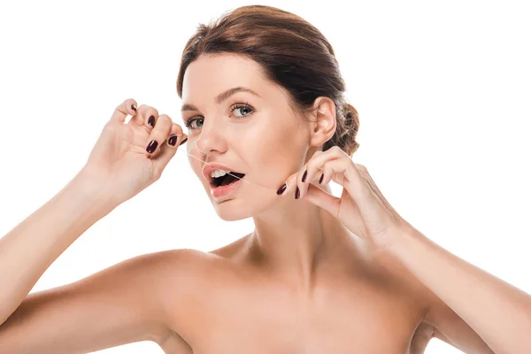 Young naked woman flossing teeth and looking at camera isolated on white — Stock Photo