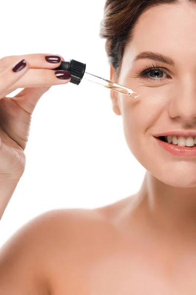 Cropped view of happy naked woman holding pipette while applying serum isolated on white — Stock Photo