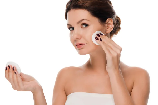 Attractive young woman holding cotton pads isolated on white — Stock Photo