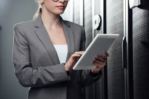 Cropped view of businesswoman holding digital tablet in server room — Stock Photo